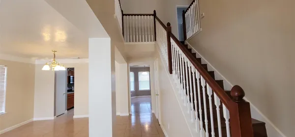 a view of a hallway with wooden floor and staircase