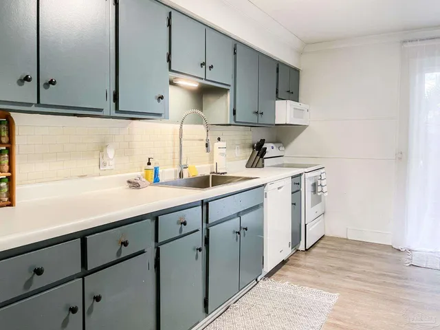 a kitchen with white cabinets and white appliances