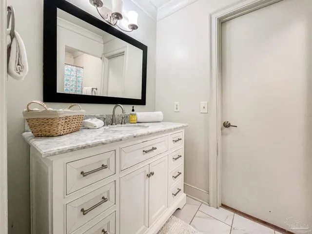 a bathroom with a granite countertop sink vanity and mirror