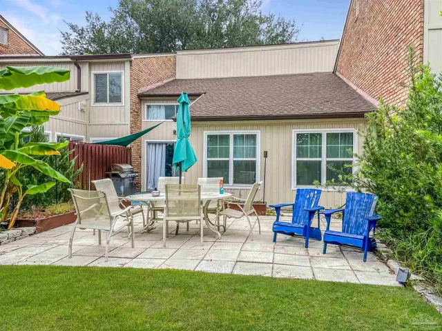 a view of house with a backyard and sitting area