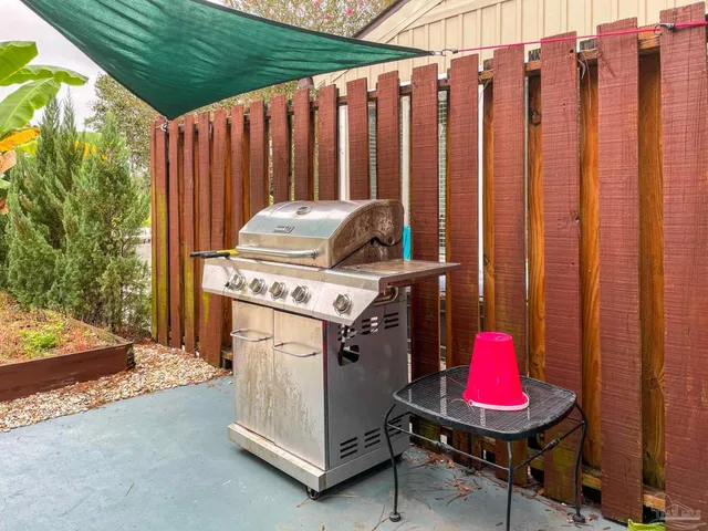 a view of a backyard with chairs and a grill