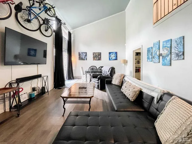 a living room with furniture a flat screen tv and a wall painting