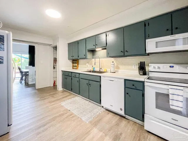 a kitchen with a sink cabinets and wooden floor