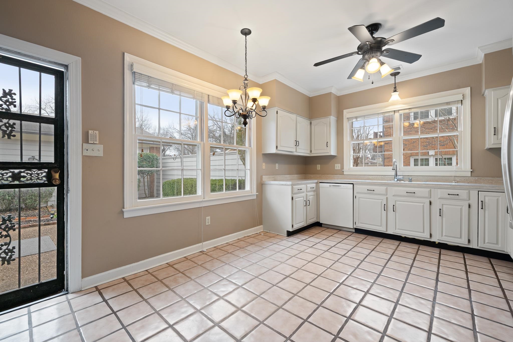 1683 Kimbrough Road Germantown, TN 38138 - Photo 11 of 34 Kitchen featuring light countertops, white cabinetry, white dishwasher, suspended lighting, and ornamental molding