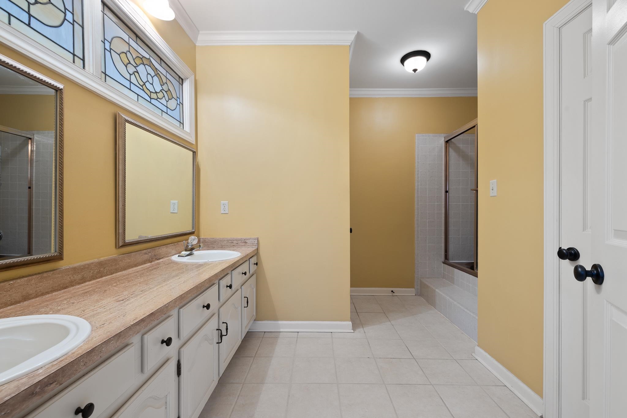 1683 Kimbrough Road Germantown, TN 38138 - Photo 17 of 34 Full bathroom featuring crown molding, double vanity, light tile patterned flooring, and a tile shower