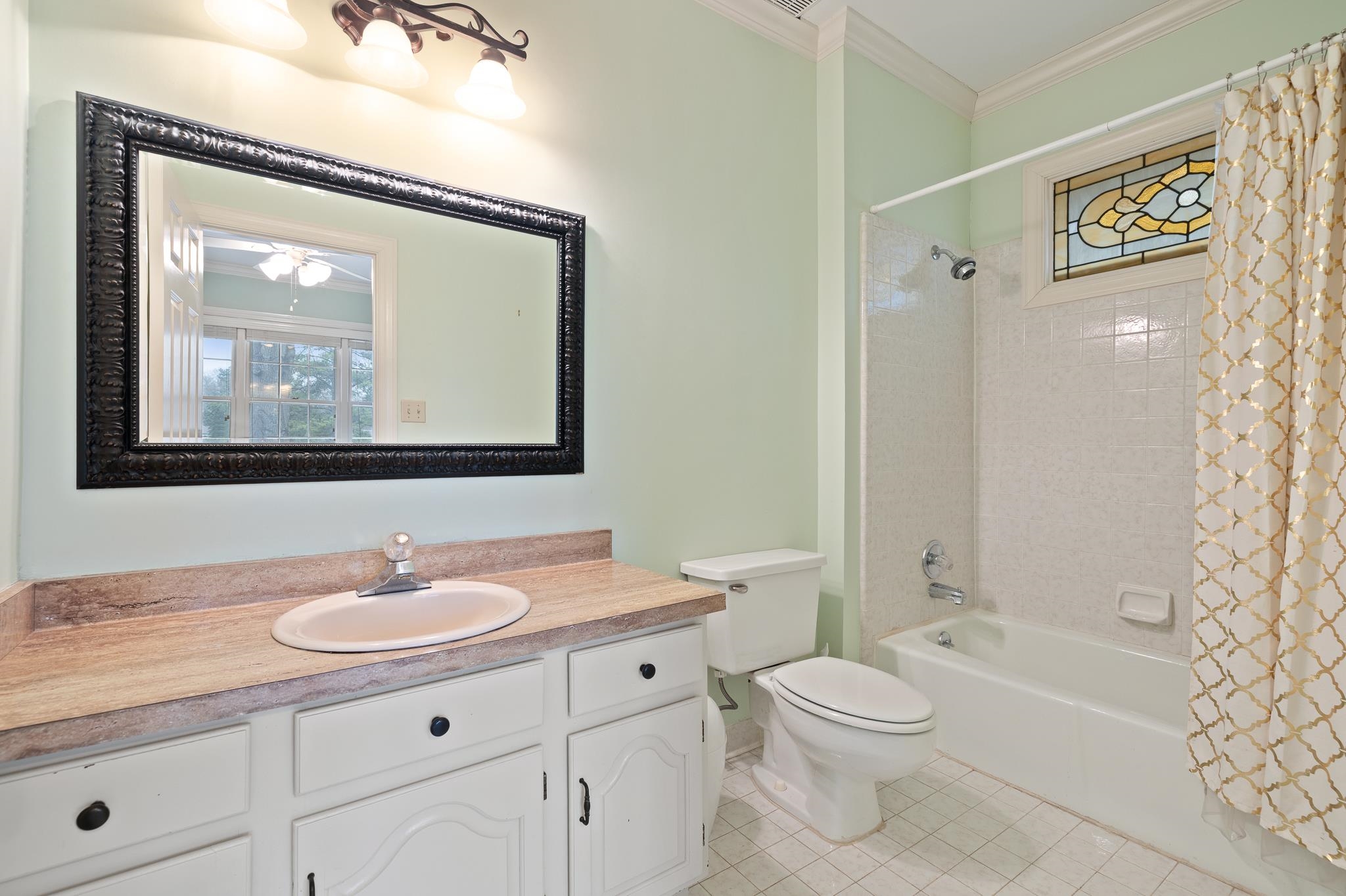 1683 Kimbrough Road Germantown, TN 38138 - Photo 23 of 34 Bathroom featuring ornamental molding, vanity, shower / bath combination with curtain, light tile patterned flooring, and healthy amount of natural light