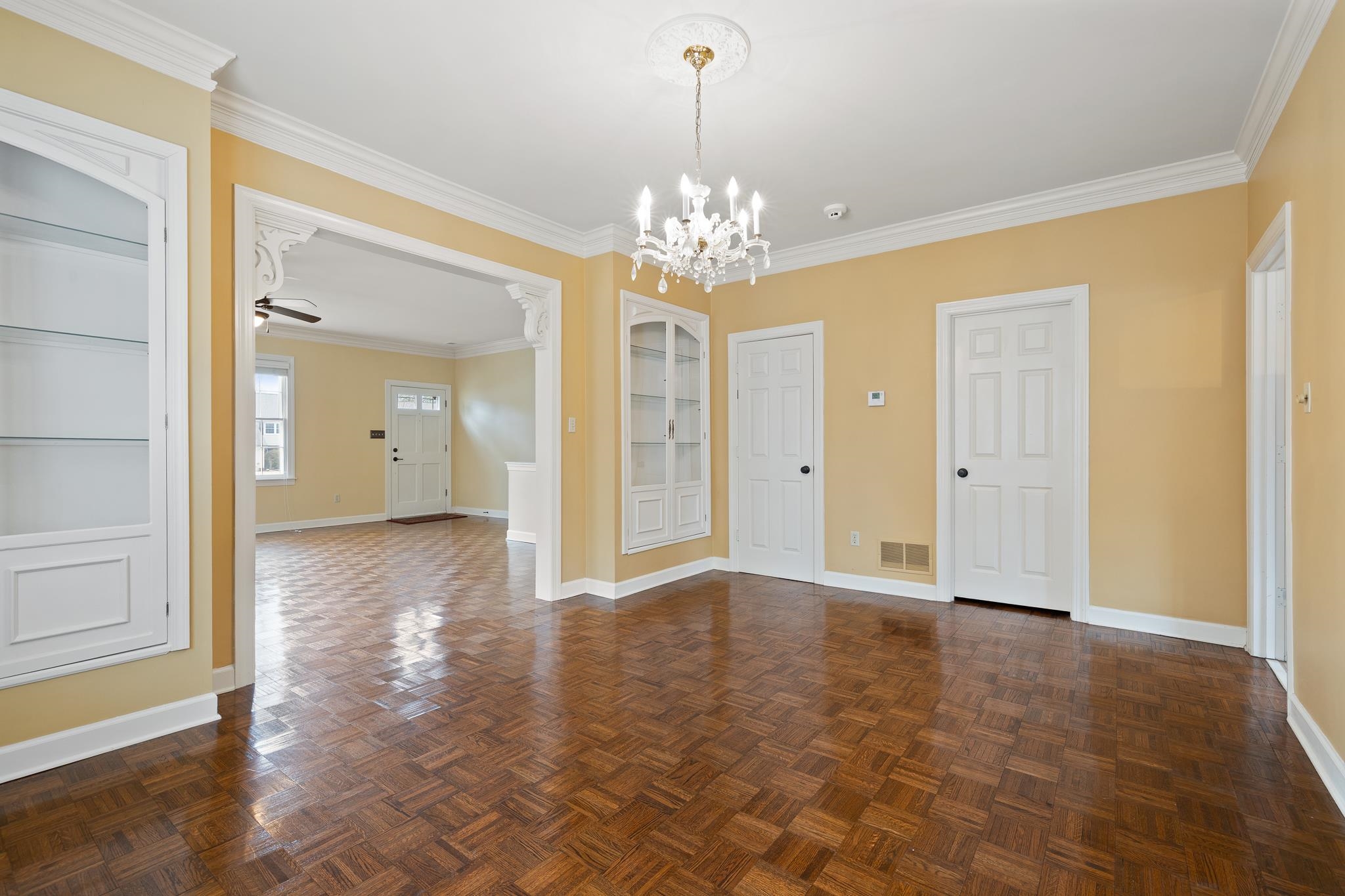 1683 Kimbrough Road Germantown, TN 38138 - Photo 8 of 34 Unfurnished dining area featuring ornamental molding, a chandelier, parquet flooring, ceiling fan, and built in shelves