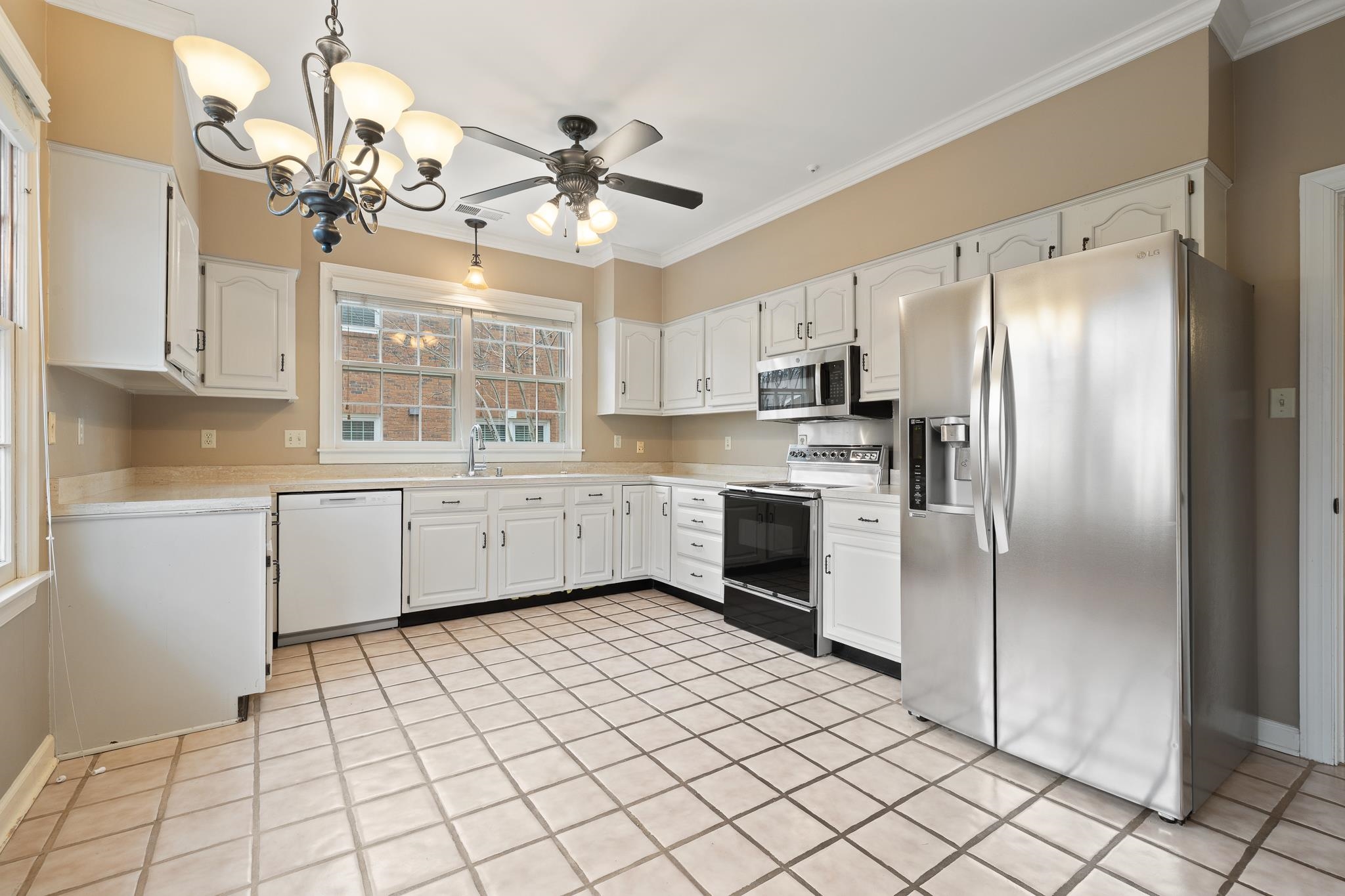 1683 Kimbrough Road Germantown, TN 38138 - Photo 9 of 34 Kitchen with stainless steel appliances, light countertops, white cabinetry, ornamental molding, and hanging lights