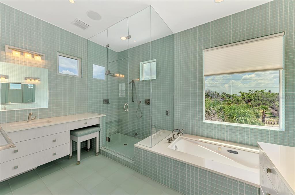 7410 Manasota Key Road Englewood, FL 34223 - Photo 28 of 45 a spacious bathroom with a granite countertop tub sink a mirror a shower and vanity