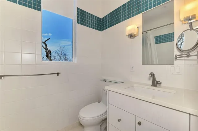 a bathroom with a toilet a sink and mirror