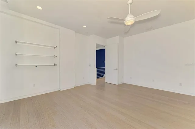 wooden floor in an empty room with a ceiling fan