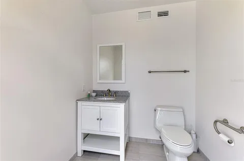 a bathroom with a toilet a sink and mirror