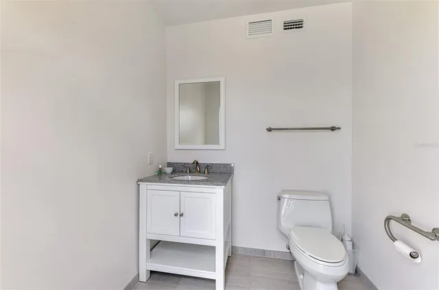a bathroom with a toilet a sink and mirror