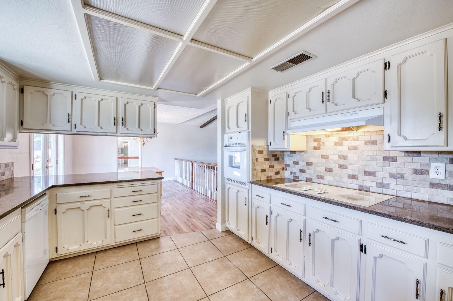22452 Goldrush Lane Clovis, CA 93619 - Photo 12 of 36 a kitchen with granite countertop white cabinets and window