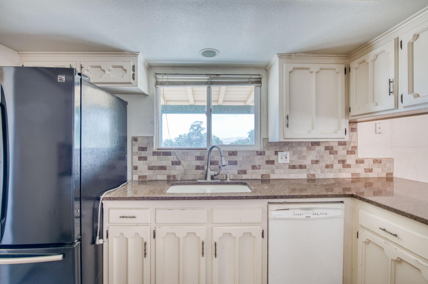 22452 Goldrush Lane Clovis, CA 93619 - Photo 13 of 36 a kitchen with stainless steel appliances granite countertop a sink and a refrigerator