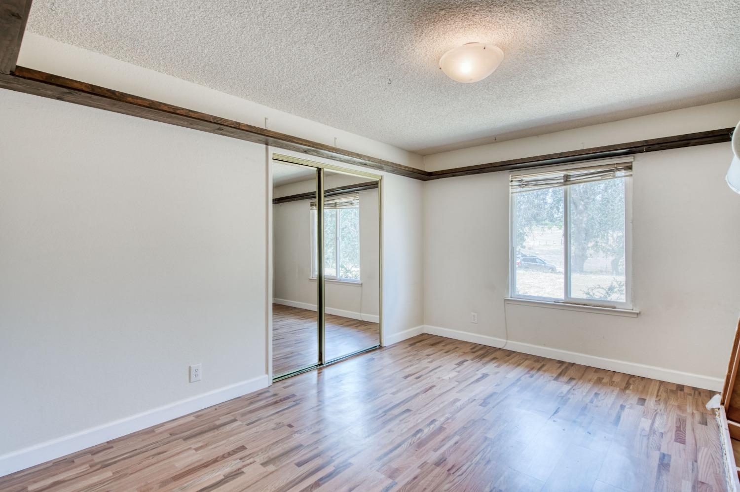 22452 Goldrush Lane Clovis, CA 93619 - Photo 20 of 36 an empty room with wooden floor and windows