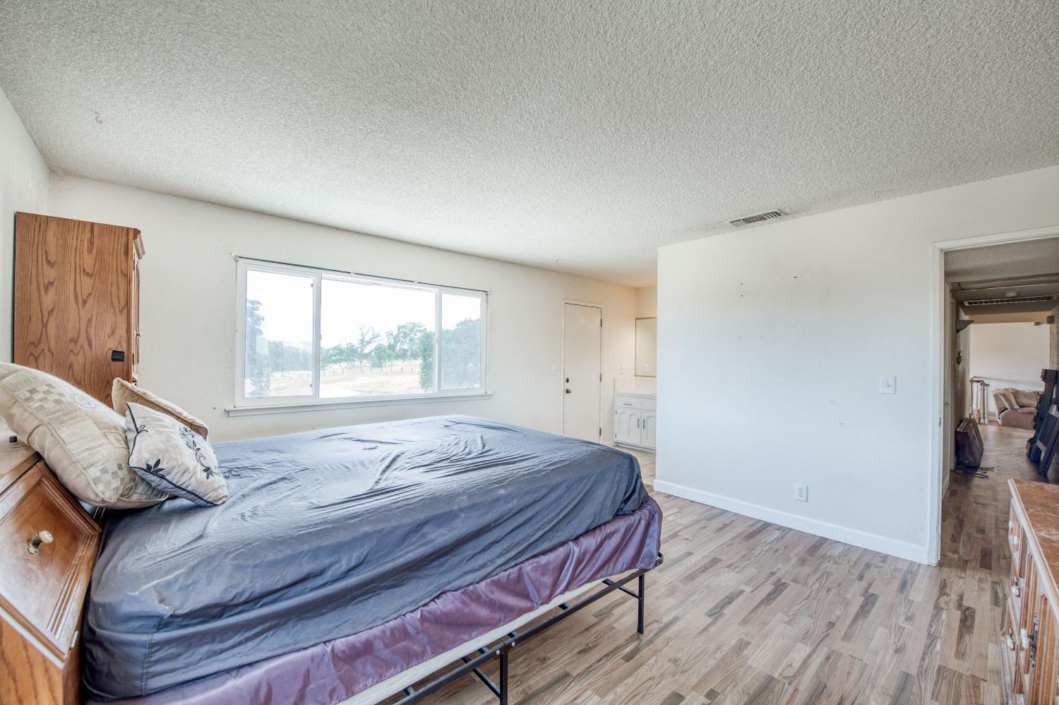 22452 Goldrush Lane Clovis, CA 93619 - Photo 22 of 36 a bedroom with a bed and wooden floor