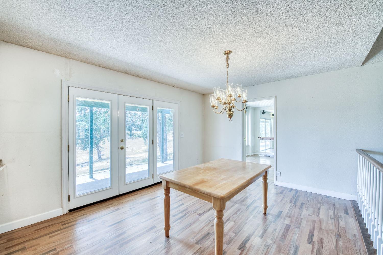 22452 Goldrush Lane Clovis, CA 93619 - Photo 9 of 36 a view of a room with wooden floor chandelier and windows