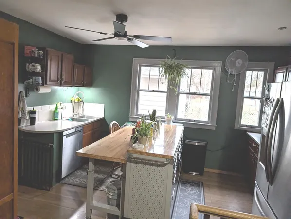 a kitchen with granite countertop a sink dining table and chairs