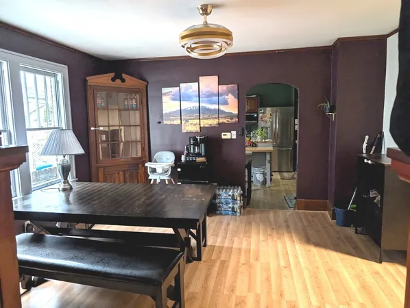 a room with wooden floor table and chairs