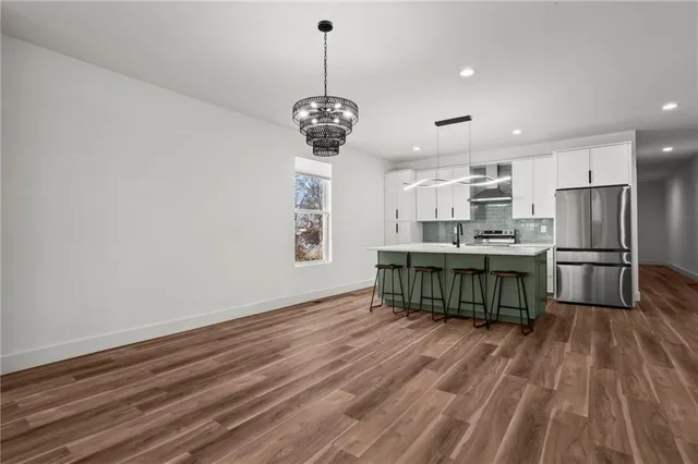 a kitchen with stainless steel appliances granite countertop a sink a stove top oven a counter space and cabinets