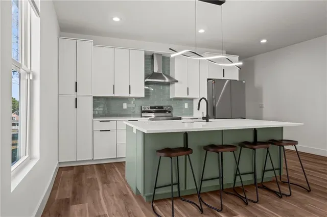 a kitchen with kitchen island granite countertop a sink cabinets and wooden floor