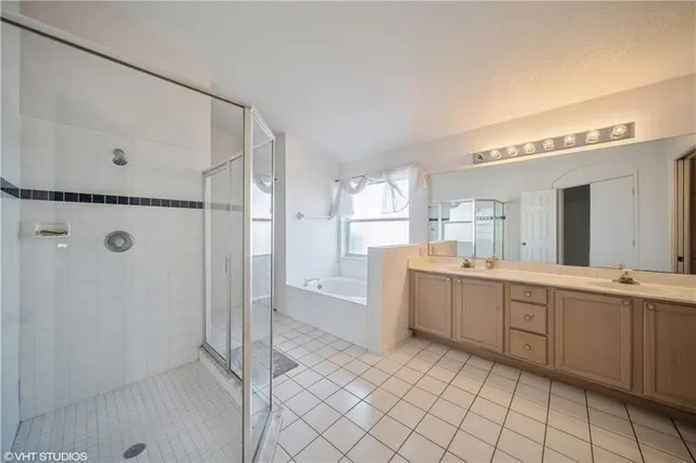 a large white bathroom with a double vanity sink and mirror