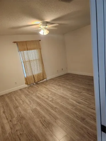 en empty room with wooden floor and window