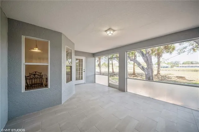 a view of an empty room with a window and front door