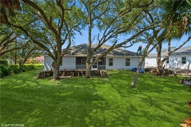 a view of a house with backyard and a tree