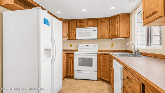 a kitchen with a refrigerator sink and cabinets