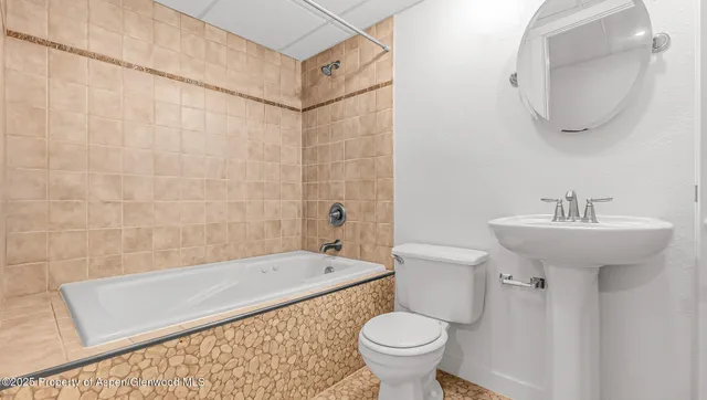 a bathroom with a sink a toilet and bathtub