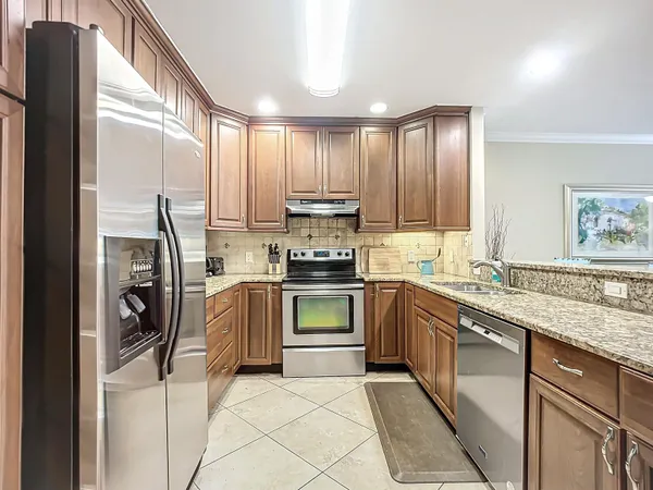 a kitchen with granite countertop cabinets stainless steel appliances and a sink