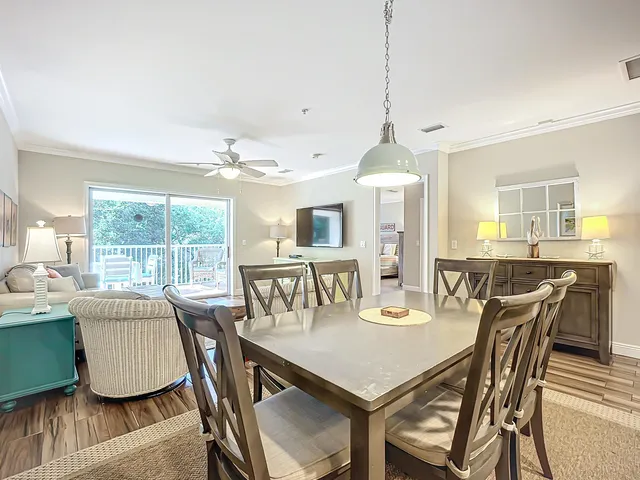 a dining room with furniture a chandelier and wooden floor