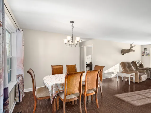a view of a dining room with furniture a chandelier and wooden floor