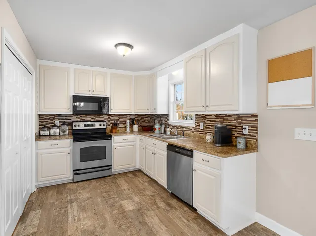 a kitchen with granite countertop white cabinets and white appliances