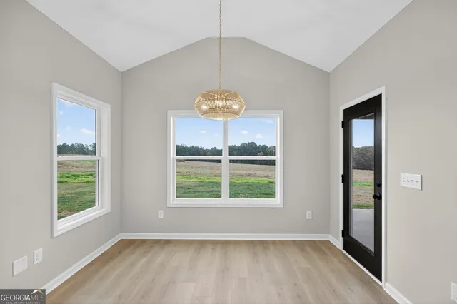 a kitchen with stainless steel appliances kitchen island granite countertop a refrigerator a sink dishwasher a stove and white cabinets with wooden floor