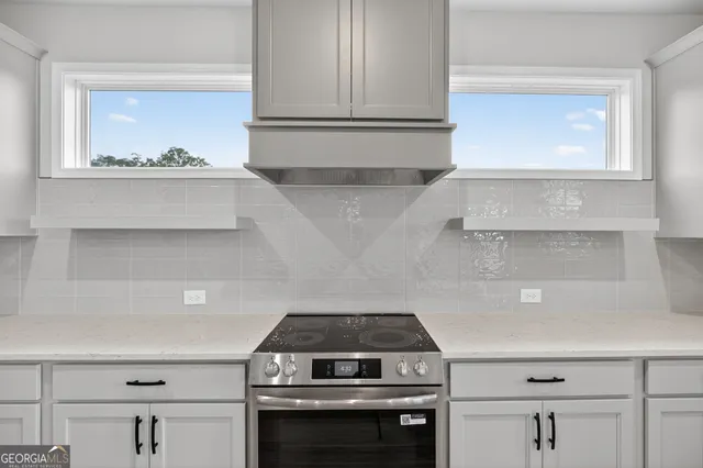 a kitchen with kitchen island a counter top space appliances and a window