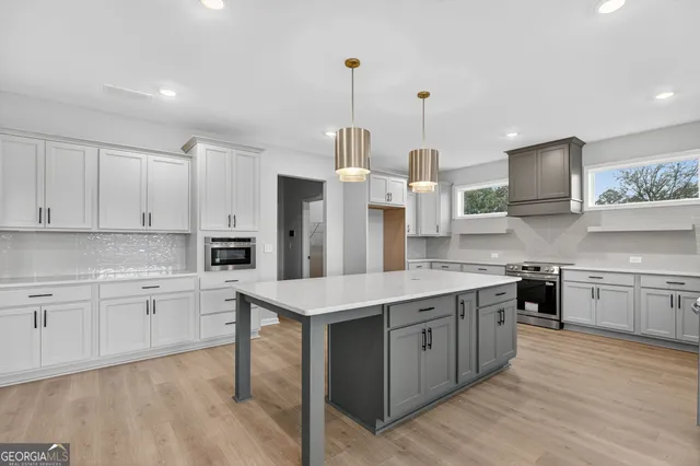 a kitchen with white cabinets and stainless steel appliances