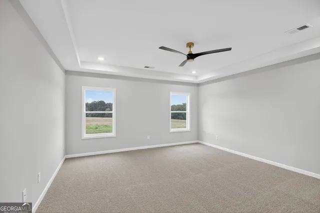 an empty room with windows and fan