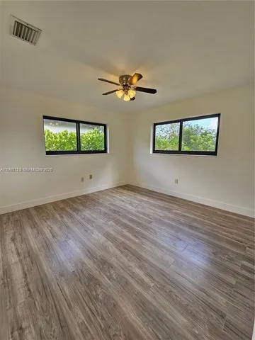 a view of room with hardwood floor and ceiling fan
