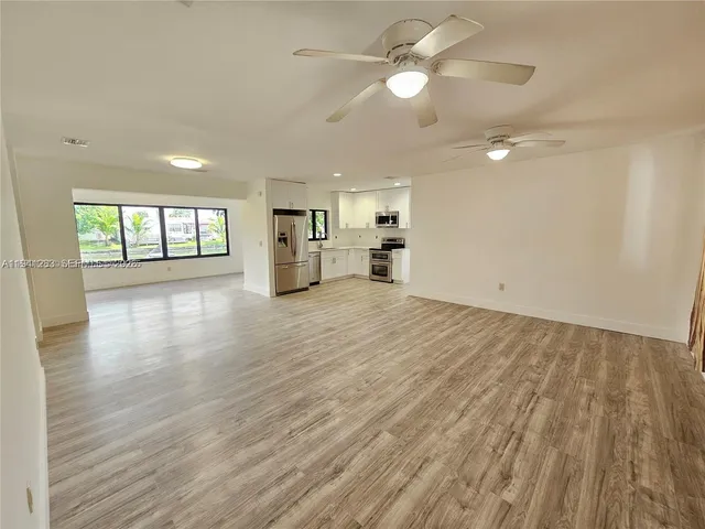 a view of a kitchen with a dishwasher cabinets and wooden floor