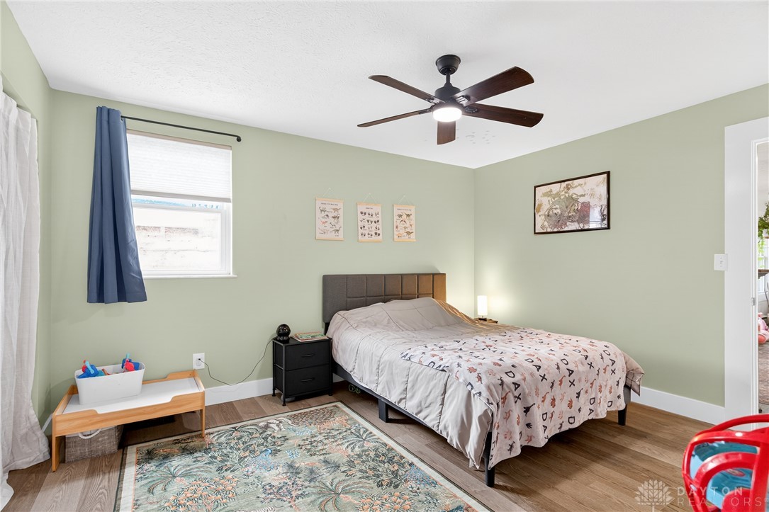 7888 Darke-Preble County Line Road Arcanum, OH 45304 - Photo 32 of 51 This cozy bedroom features durable hardwood flooring and a functional ceiling fan for comfort.
