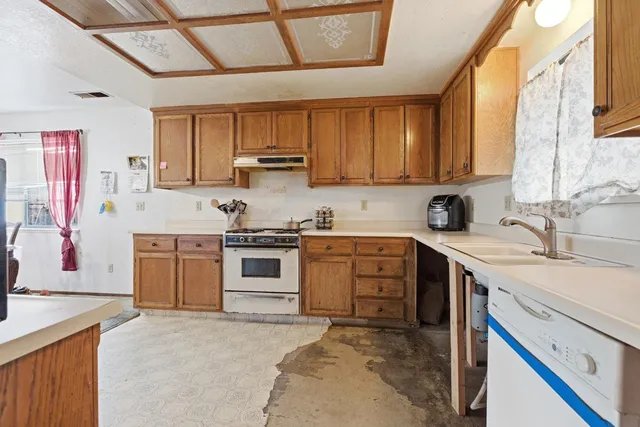a kitchen with stainless steel appliances granite countertop a stove sink and cabinets