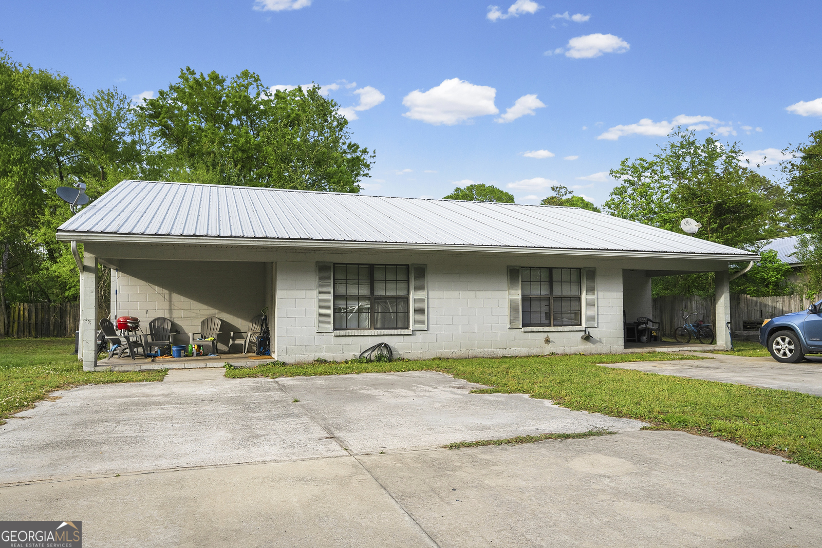 304 Cannon Street Nahunta, GA 31553 - Photo 41 of 51 a view of a white house with a swimming pool and a yard with plants