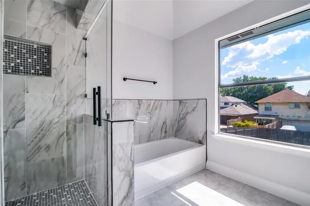 a bathroom with a bathtub and shower