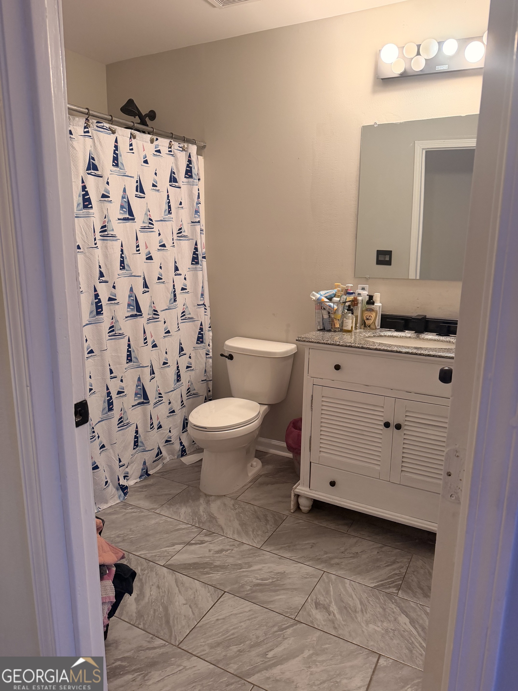 892 Perimeter Road Monticello, GA 31064 - Photo 20 of 38 a bathroom with a granite countertop toilet a sink and a mirror