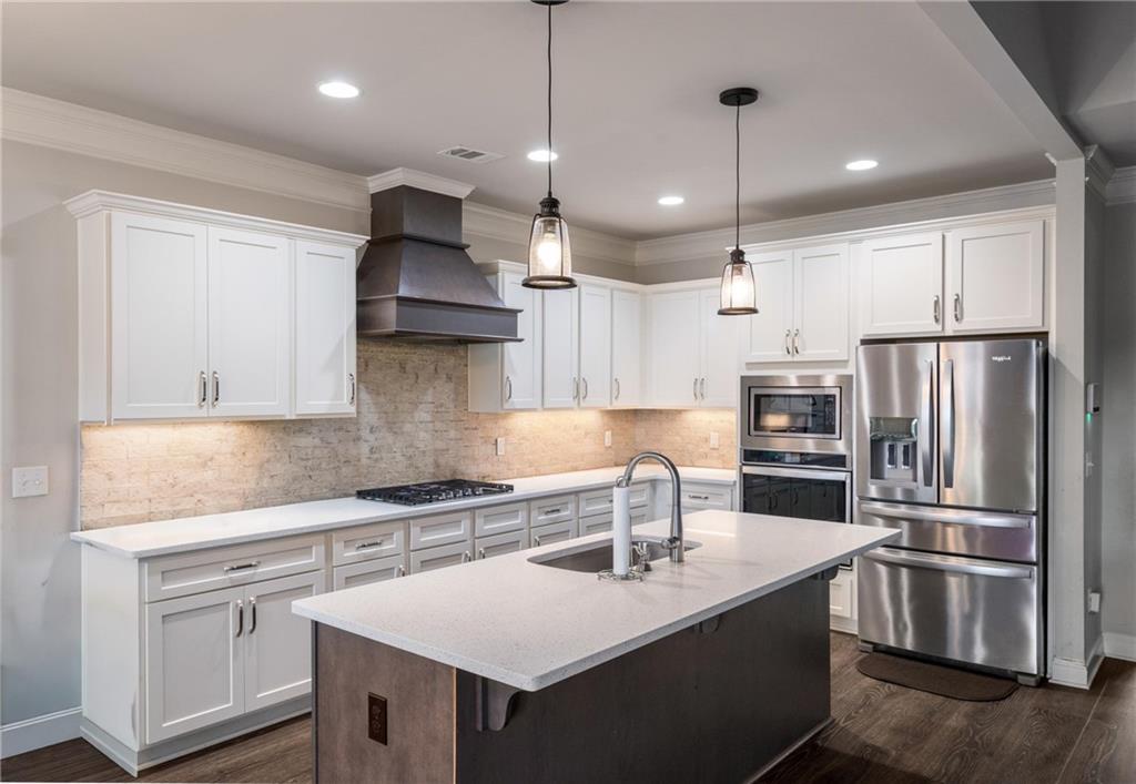 712 Fleeting Way Monroe, GA 30655 - Photo 5 of 29 a kitchen with kitchen island a sink stainless steel appliances and refrigerator