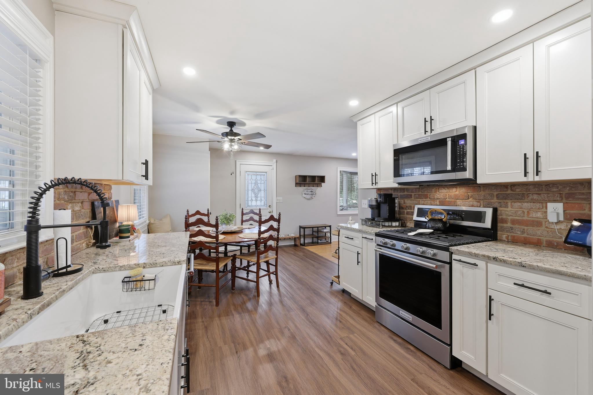 7 Anne Drive Tabernacle, NJ 08088 - Photo 9 of 44 a kitchen with stainless steel appliances granite countertop a stove top oven a sink dishwasher a dining table and chairs with wooden floor