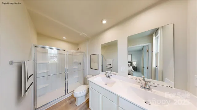 a bathroom with a double vanity sink toilet mirror and shower